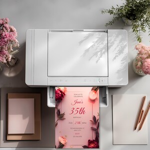 Printable pink floral birthday invitation coming out of printer, elegant minimalist design for women’s birthday, high-resolution printable invite