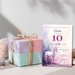 Watercolor unicorn 10th birthday invitation standing next to a pastel pink, lilac and mint wrapped gift box