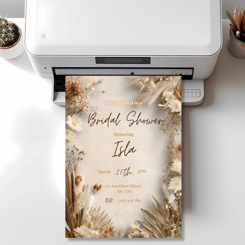 Printed boho pampas bridal shower invitation template coming out of a printer, neutral beige minimalist design, editable Canva invite