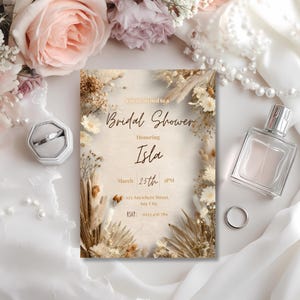 Close up of minimalist boho pampas bridal shower invitation showing neutral beige floral details and elegant typography, Canva editable