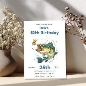Editable fishing birthday invitation displayed beside a vase of dried flowers, showing a warm styled table setting