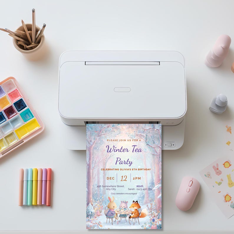 Kids winter tea party invitation printing on a home printer, a printable fox and bunny birthday invite beside pastel art supplies