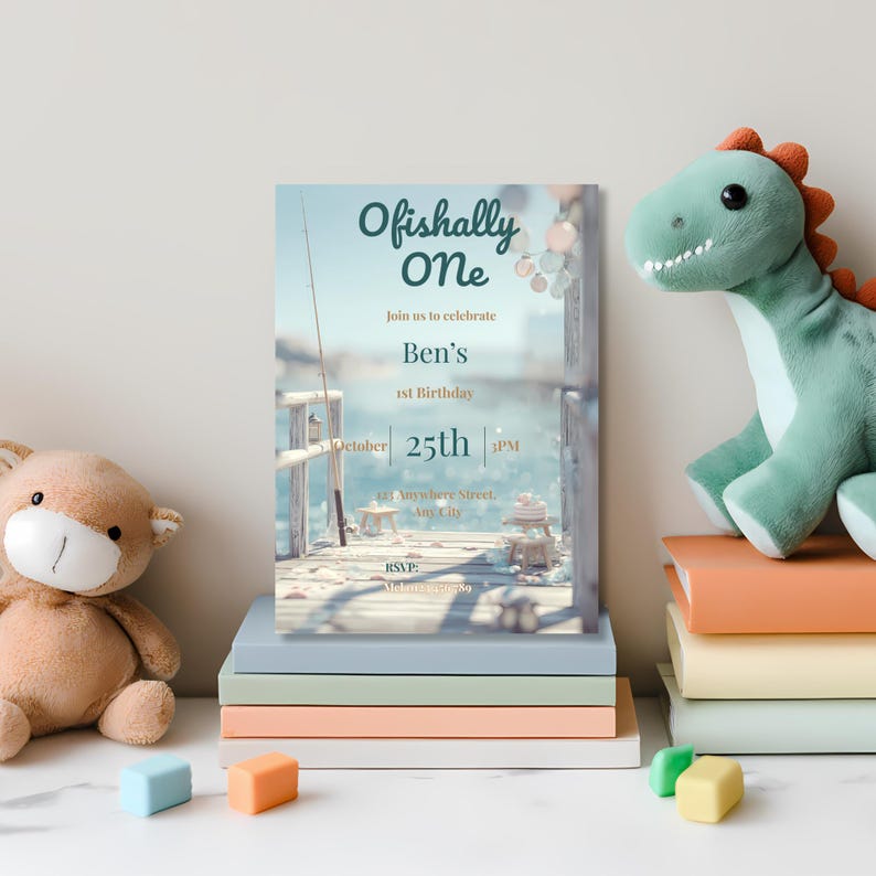 Printed fishing-themed 1st birthday invitation presented as a clean flat lay showcasing “Ofishally One” design with coastal celebration styling.