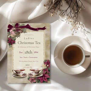 Ladies Christmas Tea Party invitation displayed beside a cup of tea for a cozy holiday tea table