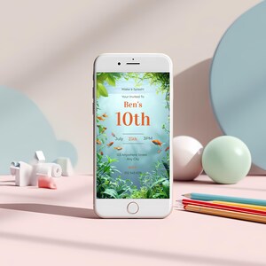 Aquarium birthday invitation displayed on a smartphone screen, showing editable underwater design with fish and plants