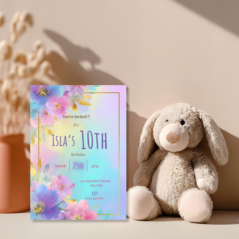 Personalized girls birthday party invitation in pastel purple pink and blue floral design displayed with soft teddy bear, editable Canva template