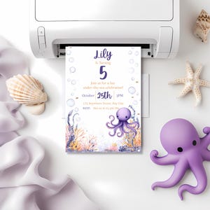 May include: A birthday invitation being printed. The invitation has an octopus and underwater plants illustration. Text reads "Lily is turning 5" with the date, time, and RSVP details. Seashells and a purple octopus toy are also visible. The invitation is for an under-the-sea celebration.