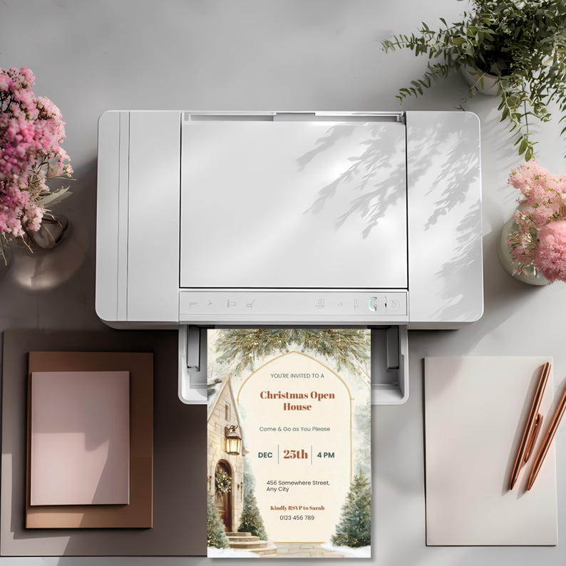 Printed Christmas Open House invitation coming out of a home printer, ready to send holiday party invite