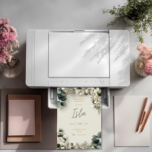 Printable bridal shower invitation coming out of printer, elegant white floral invitation template