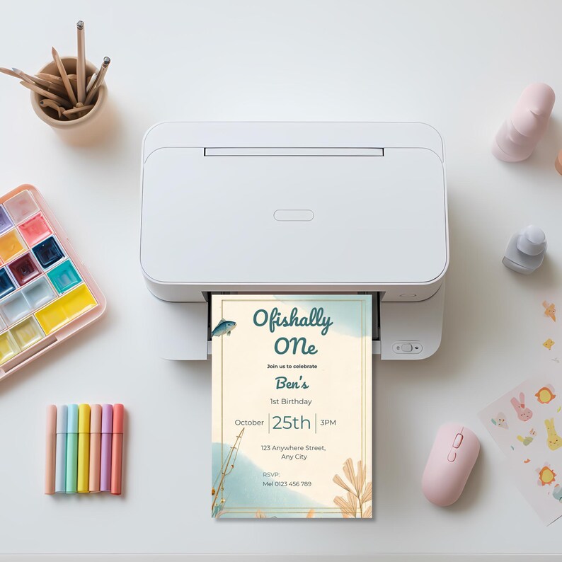 Printed Ofishally One birthday invitation coming out of a printer showing soft coastal fishing themed first birthday design