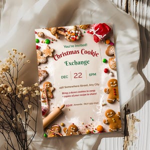 Christmas cookie exchange party invitation with gingerbread cookies and candy, angled on cream fabric beside dried flowers
