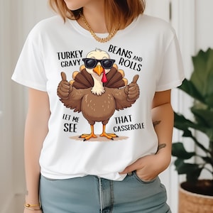 Könnte beinhalten: Weißes T-Shirt mit einem Cartoon-Truthahn, der eine Sonnenbrille trägt und den Text "Turkey Gravy Let Me See", "Beans and Rolls That Casserole".