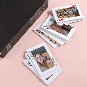 May include: A deck of playing cards with photos of people and a dog on each card. The cards are arranged in a fan shape with the Joker card on top. The text "JOKER" and "JOSEPH" are visible on the Joker card.