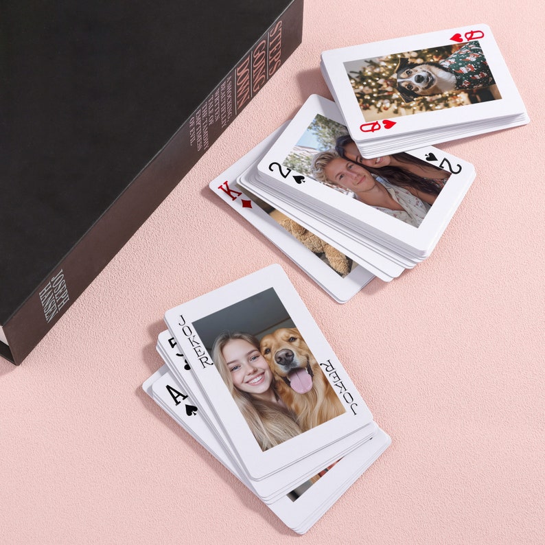 May include: A deck of playing cards with photos of people and a dog on each card. The cards are arranged in a fan shape with the Joker card on top. The text "JOKER" and "JOSEPH" are visible on the Joker card.