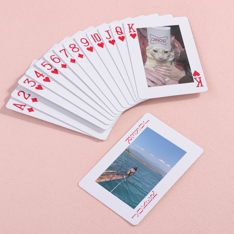 May include: A deck of playing cards with custom photos on the joker cards. The joker cards feature a cat wearing a Sonic Drive-In cup on its head and a person jumping off a dock into a lake.