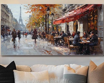 May include: A rectangular wall art print depicting a Parisian street scene with a sidewalk cafe under a red awning, autumn trees with orange foliage, and the Eiffel Tower in the distance. The painting features people walking and sitting at tables.