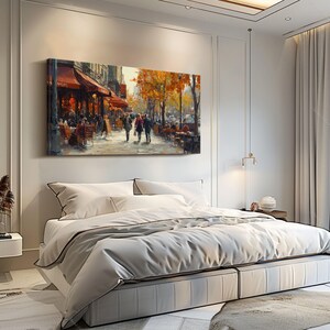 May include: A painting of a Parisian street scene with a cafe on the corner. The painting is in a bedroom setting with a white bed and white curtains.