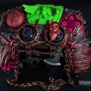 May include: Customized video game controller with a detailed, steampunk-inspired design. Features a bronze-colored skull, axe, and chain accents. The controller has a green accent and a red button layout.