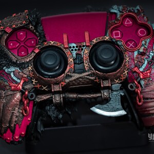 Op de afbeelding: Aangepaste videogamecontroller met een gedetailleerd ontwerp. De controller heeft een bordeauxrode en bronzen kleurenschema met ingewikkelde patronen en texturen. De knoppen en joysticks zijn zwart en het ontwerp bevat een bijldetail.