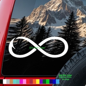 May include: White infinity symbol sticker on a vehicle window. The background features a mountain range and evergreen trees. The sticker is a simple, elegant design. The text "Lucky Rhino Designs" is visible.