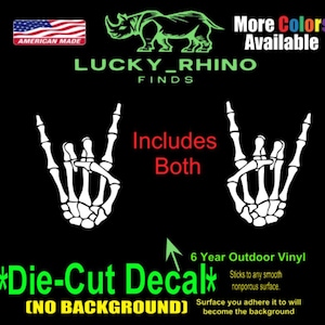 Op de afbeelding: Zwarte gestanste sticker met twee witte skelet handen in een rock-and-roll gebaar. De tekst "LUCKY_RHINO FINDS" en "More Colors Available" worden weergegeven. Inclusief beide stickers. Gemaakt in Amerika.