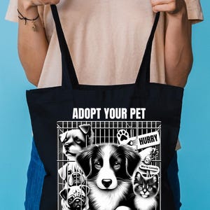 May include: Black tote bag with a white graphic of animals in cages. The graphic says "Adopt Your Pet" and "Say NO to Pet Stores". The graphic also includes the text "Hurry" and "We're Lonely".
