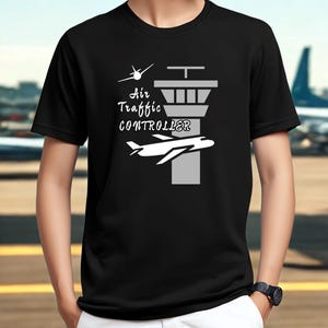 May include: Black t-shirt with a white graphic design featuring an airplane, a control tower, and the text "Air Traffic Controller". The design includes a small airplane icon and stylized text.