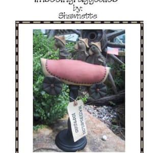 May include: A handmade felt watermelon with three crows riding on top. The watermelon is on a wooden stand with a tag that says "Watermelon Express".