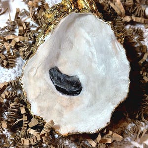 May include: A white ceramic mug with a black handle and the text "But First, Coffee" in a black, bold font. The mug is on a white surface. The mug is approximately 4 inches tall.