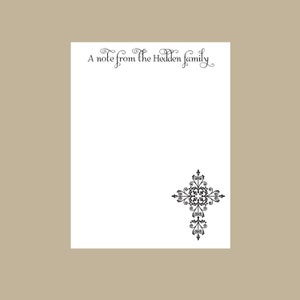 May include: A white notepad with the text "A note from the Hedden family" at the top and a black ornate cross design at the bottom.