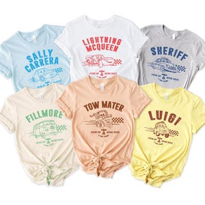 Puede incluir: Una taza de cer&aacute;mica blanca con asa negra y el texto "But First, Coffee" en negrita negra. La taza se encuentra sobre un fondo borroso, sugiriendo un ambiente acogedor.