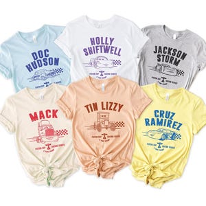 Puede incluir: Seis camisetas gr&aacute;ficas en varios colores, cada una con el nombre de un personaje diferente y una ilustraci&oacute;n de coche de la pel&iacute;cula "Cars". Los nombres son "Doc Hudson", "Holly Shiftwell", "Jackson Storm", "Mack", "Tin Lizzy" y "Cruz Ramirez".