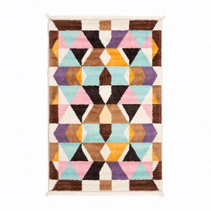 Handmade colorful wool rug featuring a bold geometric pattern with pastel pinks, blues, yellows, and earth tones. Crafted with high-quality hand-knotted wool, this modern Art Deco-inspired rug brings vibrant energy and artistic flair to living rooms, bedrooms, or creative interiors. Plush, durable, and visually striking, it creates a cozy yet dynamic atmosphere in any contemporary or eclectic space.