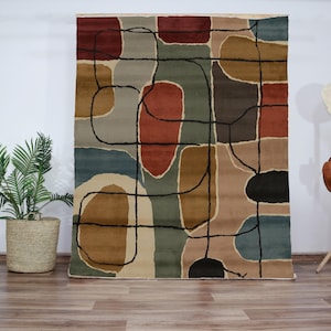 May include: Abstract area rug with a beige background and a geometric pattern in shades of brown, blue, and red.