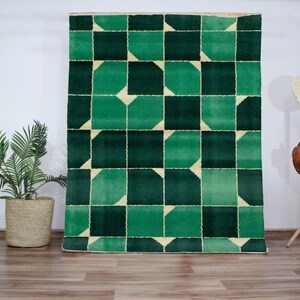 Handmade green geometric wool rug featuring bold modern Art Deco design elements, handwoven by skilled artisans using high-quality natural fibers. This luxurious area rug is perfect for adding a vibrant, graphic statement to living rooms, bedrooms, and stylish interiors. With its sharp clean lines and emerald green tones, it blends contemporary sophistication with cozy handmade warmth, ideal for designer, modern, or eclectic home decor.