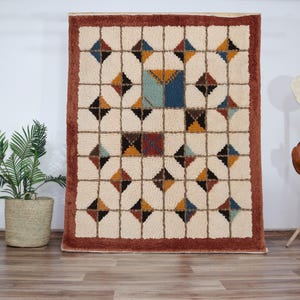 Soft, plush Moroccan Mrirt rug in a creamy wool tone, featuring a unique grid of raised square tiles. The design creates a highly tactile and dimensional surface perfect for contemporary or minimalist interiors. Hand-knotted with precision by Berber artisans, this luxurious rug adds depth, comfort, and understated style to living rooms, bedrooms, or cozy reading corners. A high-end handmade carpet for those who value both texture and design.