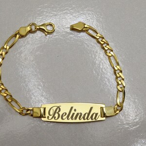 Puede incluir: Pulsera de cadena dorada con una placa rectangular con el nombre "Belinda".