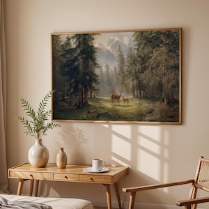 May include: A framed landscape painting depicts a forest scene with tall evergreen trees, mountains, and two deer. The artwork is displayed above a wooden desk with a vase, a small decorative vase, and a cup and saucer.