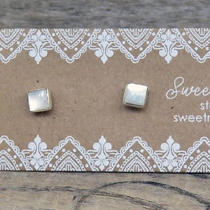 May include: Square sterling silver stud earrings on a brown card with white lace-like trim. The card reads "Sweet Rock Candy" and "sterling silver .925 sweetrockcandy.etsy.com".