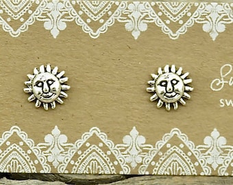 May include: A pair of silver-toned sun-shaped stud earrings attached to a rectangular brown display card. The card features a white decorative border pattern and the printed text Sweet Rock Candy and sweetrockcandy.etsy.com in white script.