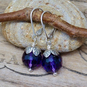 May include: Purple faceted glass bead dangle earrings with silver leaf accents and silver hooks.