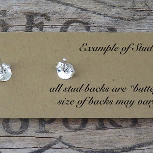 May include: A close-up of two silver earring backs on a tan card. The card has text that reads "Example of Stud Backs" and "all stud backs are 'butterfly backs' size of backs may vary by style."