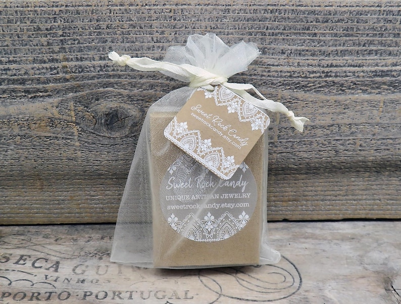 May include: A rectangular brown cardboard box inside a sheer white organza drawstring bag. A square kraft paper tag with white lace-style printing and the text Sweet Rock Candy is attached to the ribbon. A circular white sticker with the text Sweet Rock Candy Unique Artisan Jewelry is on the box.