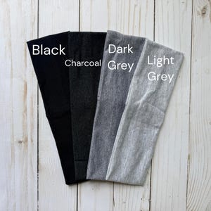Puede incluir: Cuatro diademas de tela dispuestas en abanico, con un degradado de colores de izquierda a derecha: negro s&oacute;lido, carb&oacute;n, gris oscuro y gris claro. Cada diadema est&aacute; etiquetada con el nombre de su color en una superposici&oacute;n de texto blanco.