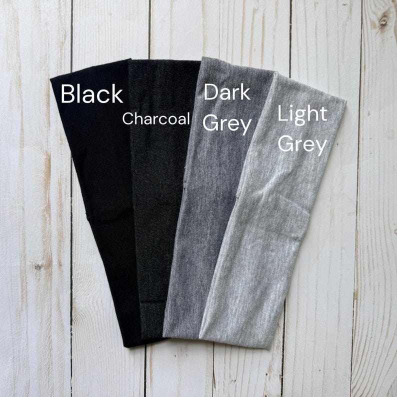 Puede incluir: Cuatro diademas de tela dispuestas en abanico, con un degradado de colores de izquierda a derecha: negro s&oacute;lido, carb&oacute;n, gris oscuro y gris claro. Cada diadema est&aacute; etiquetada con el nombre de su color en una superposici&oacute;n de texto blanco.