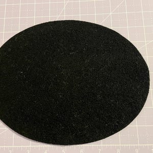May include: A black, round, felt circle. The circle is about 8 inches in diameter.