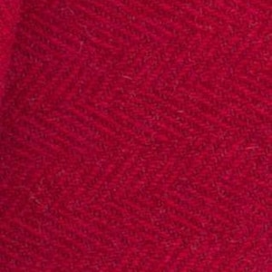 May include: A close-up of a deep red fabric with a subtle herringbone pattern. The fabric has a soft, textured feel.