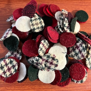 May include: A collection of assorted fabric circles in various colors and patterns. The circles include solid red, white, and green, along with patterned houndstooth and textured fabrics. These craft supplies are suitable for various DIY projects.