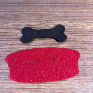 May include: A red felt dog bowl and a black felt bone. These felt pieces are great for crafts and pretend play.