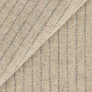 May include: Close-up of beige fabric with vertical gray pinstripes. The fabric has a textured appearance and a diagonal fold, revealing the weave and color variations. The material appears to be a woven textile.